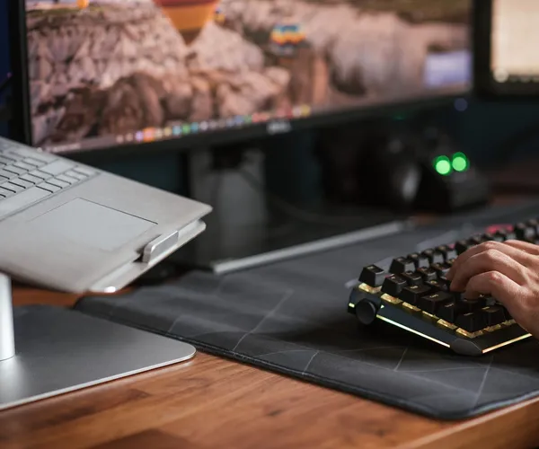 Arbeitsplatz mit Monitor, Notebook und Tastatur